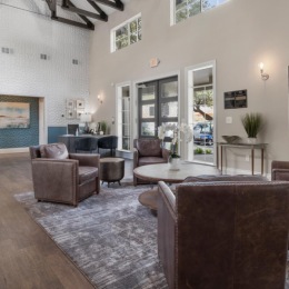 a living room with a large rug and chairs